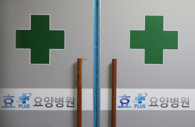 18일 신종 코로나바이러스 감염증(코로나19) 집단 감염이 발생해 코호트(동일집단 격리) 격리 중인 부천시 상동 효플러스요양병원 출입문이 굳게 닫혀 있다. 이날까지 이 요양병원에서는 병상 배정을 기다리던 70∼80대 노인 3명을 포함해 4명이 숨졌다. 연합뉴스