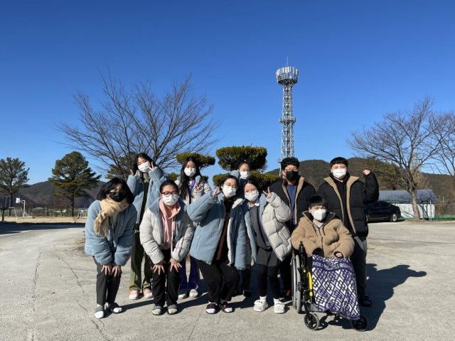 경북 의성 옥산중학교 재학생들이 졸업생들이 선물한 패딩 점퍼를 입고 포즈를 취하고 있다.