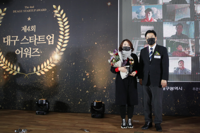 황수경 아스트로젠 대표가 대구스타트업 어워즈 대상을 수상 후 홍의락 대구시 경제부시장과 기념촬영을 하고 있다. 행사는 시상자와 수상자만 참석하고, 철저한 방역시설과 더불어 온라인 생방송 비대면 방식으로 개최됐다. 대구창조경제혁신센터 제공.