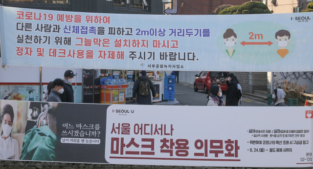 21일 오후 서울 마포구 경의선 숲길에 사회적거리두기와 마스크 의무 착용을 알리는 현수막이 설치되어 있다. 이날 서울시는 23일 0시부터 5인 이상 집합금지 행정명령을 내린다고 발표했다. 연합뉴스