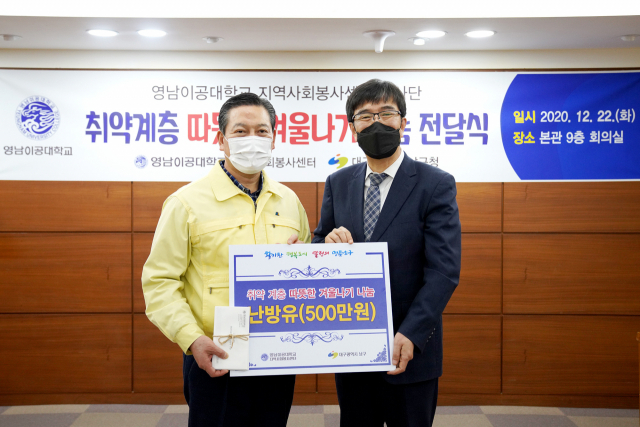 박재훈(오른쪽) 영남이공대 총장이 조재구 대구 남구청장에게 난방유를 전달하고 있다. 영남이공대 제공