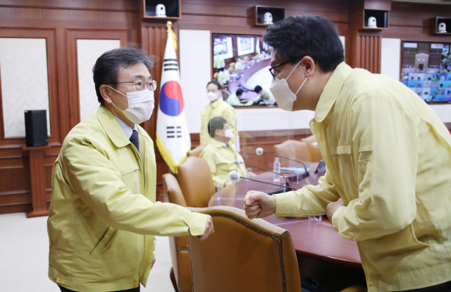 권덕철 신임 보건복지부 장관(왼쪽)이 임명된 후 처음으로 24일 오전 정부서울청사에서 열린 신종 코로나바이러스 감염증(코로나19) 대응 중앙재난안전대책본부(중대본) 회의에 참석해 인사하고 있다. 연합뉴스