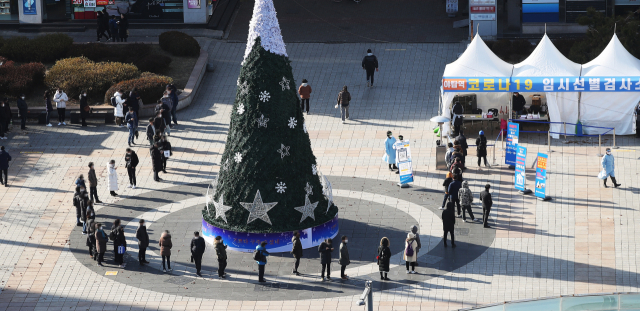 크리스마스이브인 24일 오후 경기도 성남시 야탑역 광장에 설치된 신종 코로나바이러스 감염증(코로나19) 임시 선별진료소에 시민들이 검사를 받기 위해 줄을 서 있다. 연합뉴스