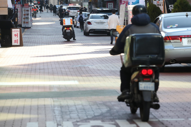 코로나19 확진자 급증과 한파로 인해 14일 오후 서울 강남구 식당가에서 라이더들이 음식 배달을 나서고 있다. 연합뉴스