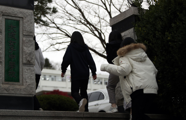 지난 20일 광주 남구 한 여자고등학교에서 귀가한 1학년 학생이 코로나19 진단검사를 받기 위해 학교로 돌아가고 있다. 이 학교 1학년 학생이 자가격리 중 코로나19 양성 판정을 받으면서 동급생 전체가 진단검사를 받았다. 연합뉴스