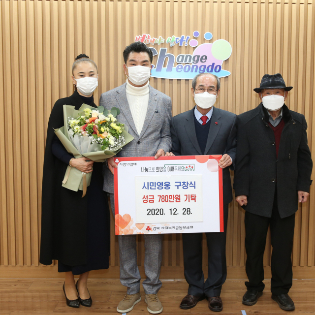 지난 10월 울산 주상복합아파트 화재 사고 당시 이웃 주민 18명을 대피시켜 화제를 모은 구창식(왼쪽 두번째) 씨가 28일 고향 청도군을 방문해 포상금을 기탁하고 있다. 청도군 제공