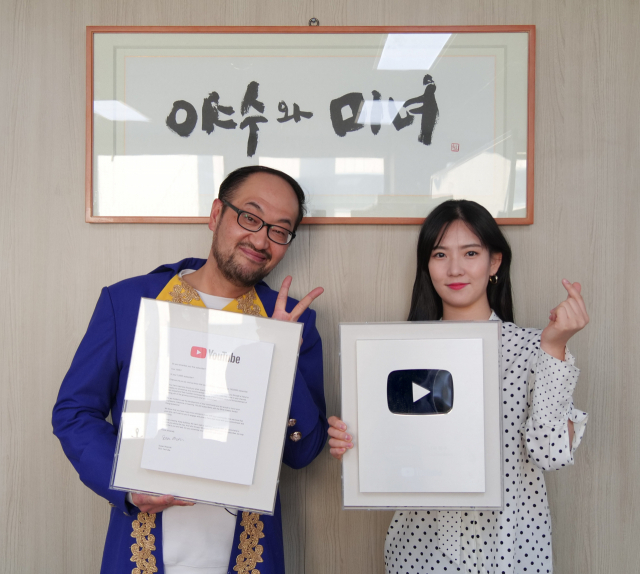 미국 유튜브 본사로부터 받은 실버버튼과 인증서를 들고 있는 TV매일신문 