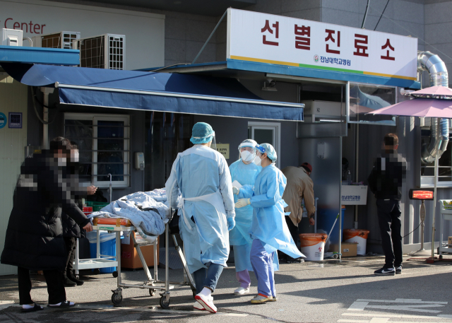 광주 동구 전남대학교병원 선별진료소에서 의료진이 타병원에서 온 한 환자를 신종 코로나바이러스 감염증(코로나19) 검체 채취를 위해 이송하고 있다. 연합뉴스