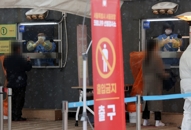 29일 오후 서울광장에 마련된 코로나19 임시선별진료소에서 의료진이 검사 준비를 위해 장갑을 착용하고 있다. 연합뉴스