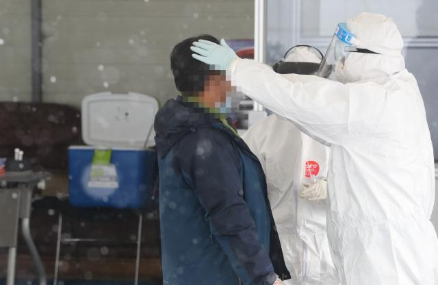 낮 기온이 영하 7도에 머무는 등 세밑 한파가 찾아온 30일 선별진료소에서 의료진이 검체를 채취하고 있다. 연합뉴스