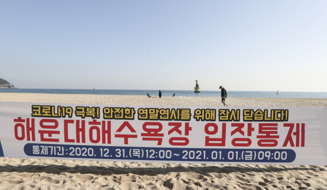 정부가 신종 코로나바이러스 감염증(코로나19) 확산을 막기 위해 새해 주요 해돋이 명소를 일시 폐쇄키로 한 가운데 28일 부산 해운대해수욕장에 새해 해맞이 행사를 금지하기 위해 오는 31일 정오부터 1월 1일 오전 9시까지 입장을 통제한다는 안내 현수막이 부착되어있다. 연합뉴스