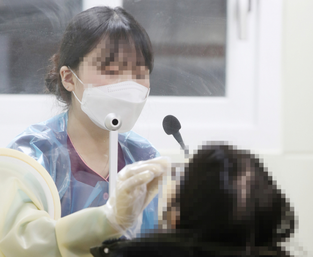 인천공항 코로나19 검사센터 운영이 시작된 31일 오후 인천국제공항 제2 터미널에 마련된 검사센터에서 한 시민이 검체 검사를 받고 있다. 연합뉴스