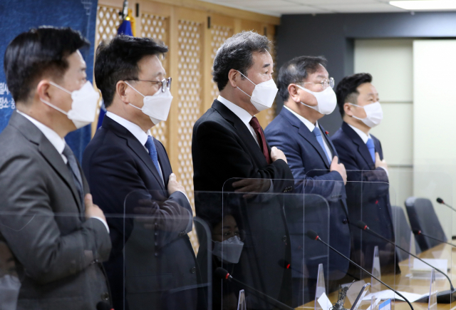 1일 오전 서울 여의도 당사에서 열린 더불어민주당 2021년 온택트 신년인사회에서 이낙연 대표와 김태년 원내대표 등이 국기에 대한 경례를 하고 있다. 연합뉴스