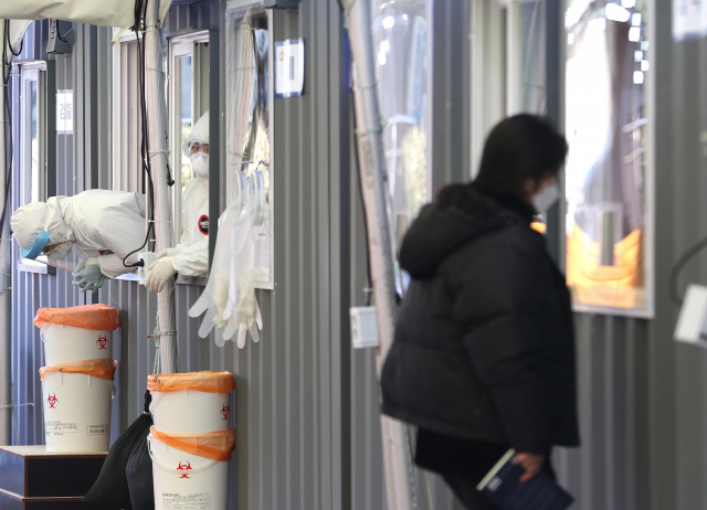 세밑 한파가 찾아온 지난달 30일 오전 서울역광장에 마련된 코로나19 임시선별진료소에서 의료진이 손을 모으고 있다. 사진은 기사 내용과 관련 없음. 연합뉴스