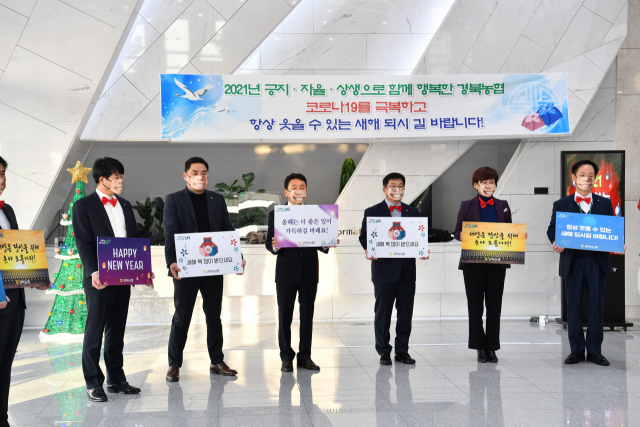 4일 경북농협 간부들이 출근하는 직원들에게 인사말을 담은 보드판을 들어 보이고 있다. 경북농협 제공