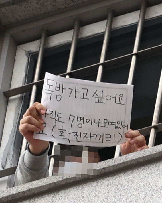 지난 3일 오후 신종 코로나바이러스 감염증(코로나19) 확진자가 다수 발생 중인 서울 송파구 동부구치소에서 한 수용자가 취재진에게 메모를 보여주고 있다. 연합뉴스