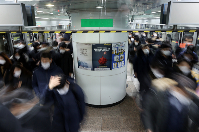 지난해 서울 지하철에서 시민들이 마스크를 착용한 채 출근하고 있다. 연합뉴스