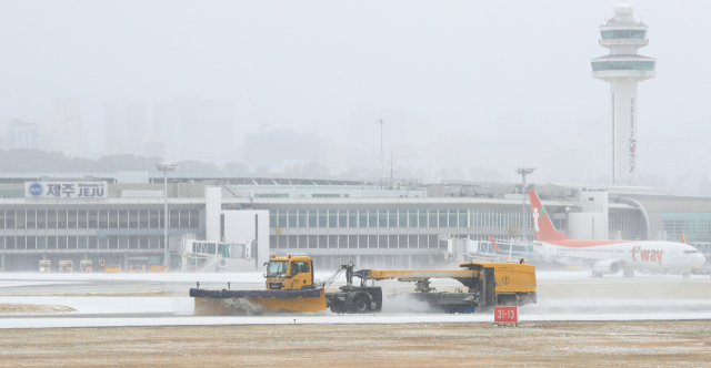 제주에 많은 양의 눈이 내린 7일 오후 제주국제공항 활주로에서 특수차량이 눈을 치우고 있다. 연합뉴스