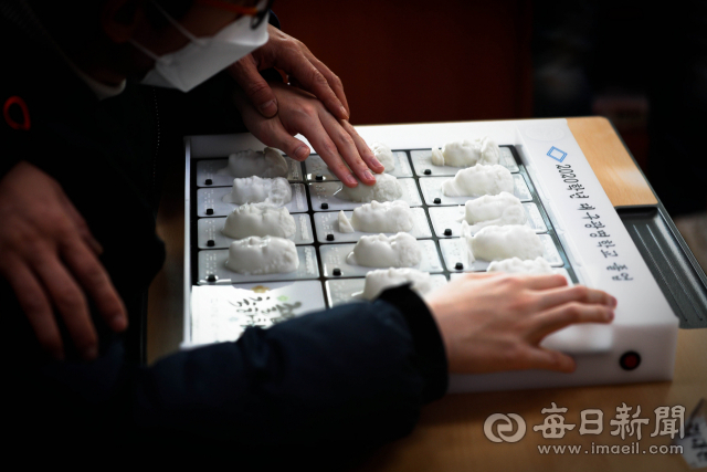 15일 시각장애 학생 교육기관인 대구 광명학교에서 열린 졸업식에서 3D 프린터로 제작된 졸업앨범을 받은 초등부 6학년 학생이 앨범 속 급우들의 얼굴을 만지고 있다. 크리에이티브팩토리의 도움을 받아 3D 입체 앨범을 지난해 처음으로 졸업생들에게 전달한 광명학교는 올해 졸업생 22명에게도 급우들의 얼굴과 음성파일이 담긴 특별한 졸업앨범을 선사했다. 우태욱 기자 woo@imaeil.com