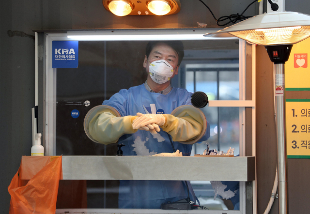 국민의당 안철수 대표가 15일 서울광장에 마련된 임시 선별검사소에서 의료 자원봉사에 나서 검체채취를 준비하고 있다. 연합뉴스