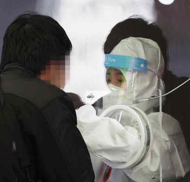 1월24일 오후 서울역광장에 설치된 임시선별진료소에서 의료진이 검체를 채취하고 있다. 연합뉴스