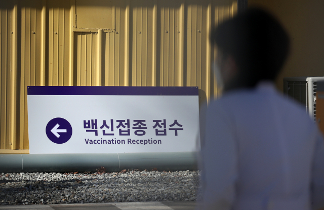29일 서울 중구 옛 미 극동 공병단 부지에 마련된 국립중앙의료원 코로나19 백신중앙접종센터에서 한 관계자가 안내판 앞을 지나고 있다. 이곳에 설치된 백신중앙접종센터에서 코로나19 환자를 치료하는 의료진을 대상으로 초기 접종을 시작하고 예방접종센터 표준모델을 마련한다. 또 권역·지역에 마련된 접종센터 인력에 대한 교육도 맡는다. 연합뉴스