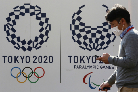 1일 일본 도쿄에서 한 남성이 2020 도쿄올림픽 로고가 그려진 거리를 걷고 있다. AP·연합뉴스