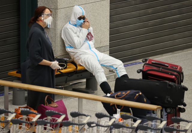3일 오후 인천국제공항 제1여객터미널을 통해 입국한 중국인이 방역복을 착용한 채 경찰 인솔을 받아 자가격리 시설로 이동하기 전 대기하고 있다. 중앙방역대책본부에 따르면 이달 1일 이후 국내에서 코로나19 양성 판정을 받은 확진자 27명의 유전체를 분석한 결과 5건에서 변이 바이러스가 확인됐다. 특히 이날 기존 신종 코로나바이러스 감염증(코로나19)보다 전파력이 더 센 것으로 알려진 변이 바이러스의 지역사회 집단전파 사례가 처음으로 확인돼 우려가 나오고 있다. 연합뉴스