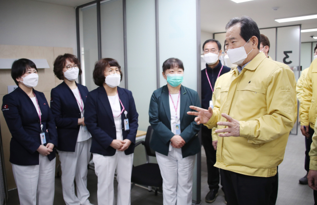 정세균 국무총리가 6일 서울 중구 국립중앙의료원 코로나19 백신 중앙예방접종센터를 방문해 문진표를 작성하고 체온을 측정하는 대기구역과 예진과 백신 접종을 시행하는 접종구역, 접종 후 이상반응을 모니터링하는 관찰구역을 차례로 둘러보며 의료진과 대화하고 있다. 연합뉴스