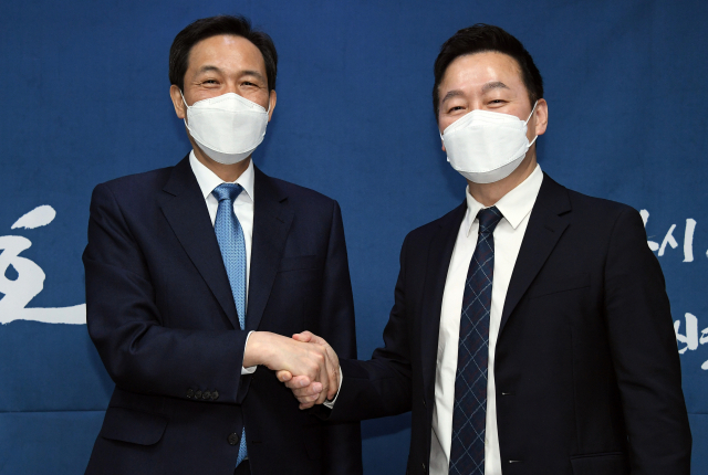 더불어민주당 우상호 서울시장 보궐선거 예비후보(왼쪽)와 열린민주당 정봉주 서울시장 보궐선거 예비후보가 7일 오전 국회 의원회관에서 만나 범여권 서울시장 후보 단일화 합의를 발표하고 악수하고 있다. 연합뉴스