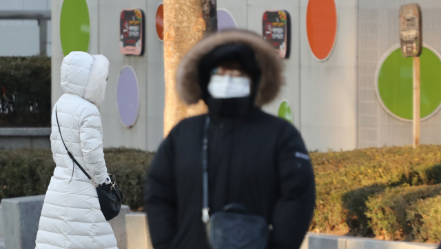 반짝 추위가 찾아 온 8일 오전 서울 시내에서 시민들이 모자를 쓰고 지나가고 있다. 연합뉴스
