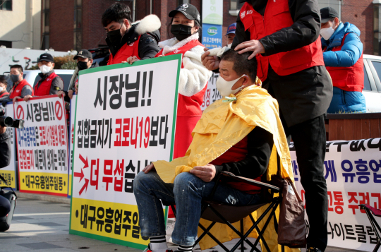 대구지역 클럽 및 나이트클럽 업주들이 10일 오후 대구시청 앞에서 집회를 열고 유흥업소 집합금지 명령 철회 등을 촉구하며 삭발을 하고 있다. 김영진 기자 kyjmaeil@imaeil.com