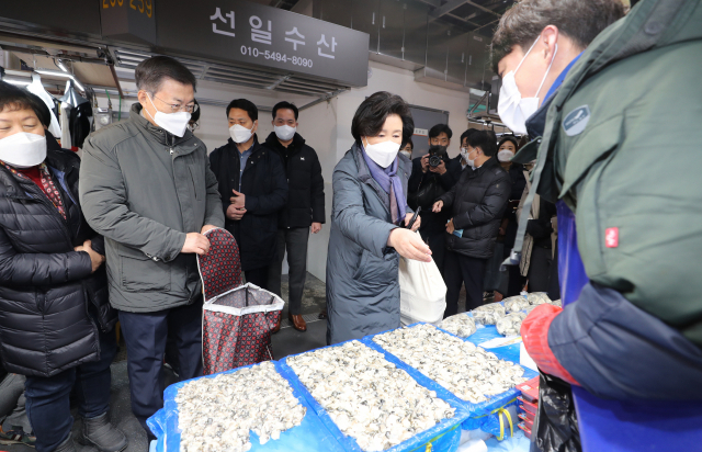 문재인 대통령과 부인 김정숙 여사가 10일 오전 인천시 남동구 소래포구 전통어시장을 방문, 상점에서 생굴을 구입하고 있다. 연합뉴스