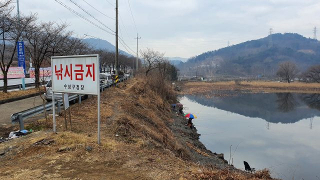 설 연휴 기간인 지난 14일 찾은 대구 수성구 고산지역의 한 저수지. 낚시금지를 알리는 팻말이 서 있지만, 낚시꾼들이 즐비하다. 쓰레기가 곳곳에 나뒹굴고 모아 놓은 쓰레기와 불에 태운 쓰레기도 보인다.