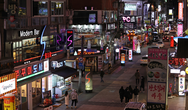 수도권 사회적 거리두기 조치가 2단계로 완화된 15일 오후 9시경 서울 송파구 잠실새내역 인근 거리에 위치한 가게 간판들이 밝게 켜져 있다. 이날부터 수도권 식당과 카페의 영업시간 제한은 오후 9시에서 10시로 1시간 늦춰진다. 연합뉴스