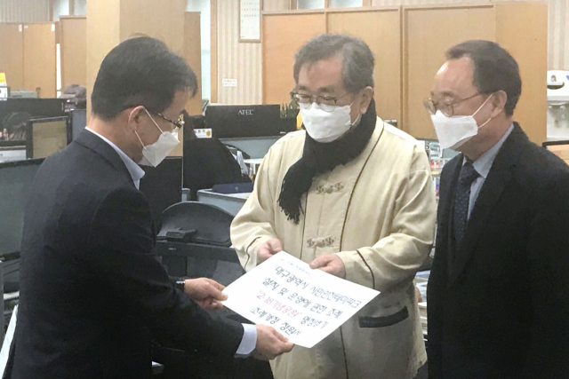 2·18안전문화재단 김태일 이사장(가운데)과 김동식 대구시의원(오른쪽)이 17일 대구시의회에 시민안전테마파크 명칭 병기를 위한 청원서를 제출했다. 재단은 2003년 중앙로역 지하철 화재 참사를 계기로 개관한 시민안전테마파크에서 참사 관련 명칭과 흔적을 찾아볼 수 없다며 안전테마파크 설치 및 운영에 관한 조례 명칭에 