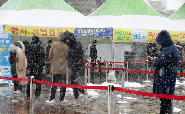 17일 광주 서구 시청광장에 설치된 신종 코로나바이러스 감염증(코로나19) 임시 선별검사소에서 시민들이 눈을 맞으며 대기하고 있다. 연합뉴스