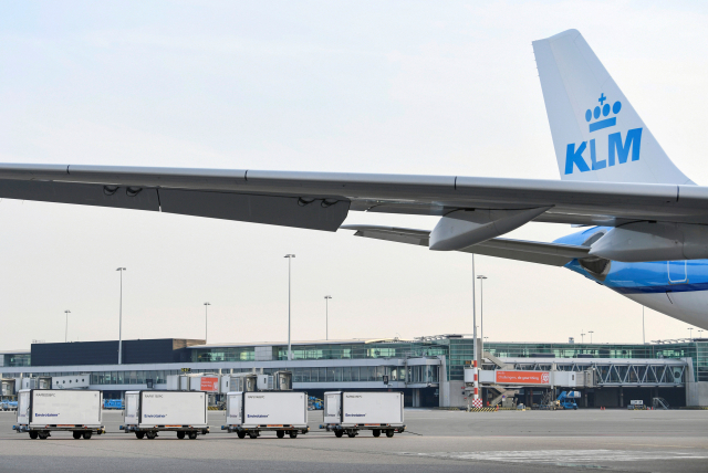 에어프랑스-KLM 항공사의 화물사업부가 네덜란드 암스테르담의 스히폴 공항을 통해 신종코로나바이러스감염증(코로나19) 백신과 후보 물질의 대규모 운송작업을 준비하고 있는 가운데 이 공항 활주로에 대기하고 있는 KLM 여객기 뒤로 냉동 컨테이너들이 보인다. 연합뉴스
