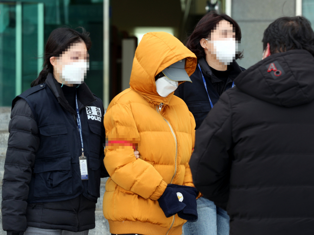 생후 2주 된 아들을 폭행해 살해한 혐의로 구속 송치된 아내 B(22)씨가 18일 오후 전북 전주덕진경찰서 앞에서 취재진 질문을 받고 있다. 연합뉴스