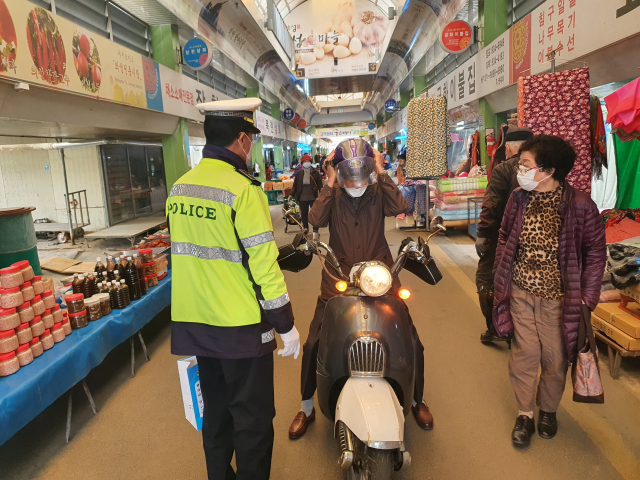 경북 의성경찰서 교통 경찰관이 의성전통시장에서 오트바이 운전자에게 교통 안전 등에 대해 홍보하고 있다. 의성경찰서 제공