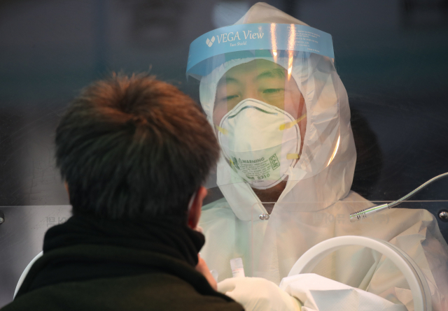 20일 오전 서울 중구 서울역 광장 신종 코로나바이러스 감염증(코로나19) 임시 선별 검사소에서 의료진이 시민의 검체를 채취하고 있다. 중앙방역대책본부는 이날 0시 기준으로 코로나19 신규 확진자가 446명 늘어 누적 8만6천574명이라고 밝혔다. 전날보다 115명 줄었다. 연합뉴스