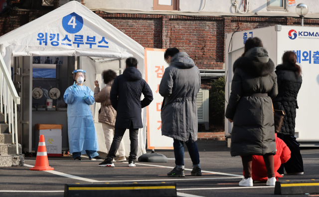 국내 신종 코로나바이러스 감염증(코로나19) 신규 확진자 수가 416명을 기록한 21일 오전 서울 중구 국립중앙의료원에 마련된 코로나19 워킹스루 선별진료소에서 시민들이 검사를 위해 대기하고 있다. 연합뉴스