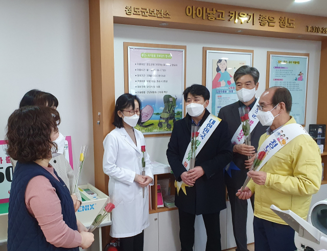 이승율 청도군수와 김수태 군의회 의장, 박기화 농협 청도군지부장이 22일 청도군보건소를 찾아 사랑의 꽃을 전달하며 위로의 말을 전하고 있다. 농협 청도군지부 제공