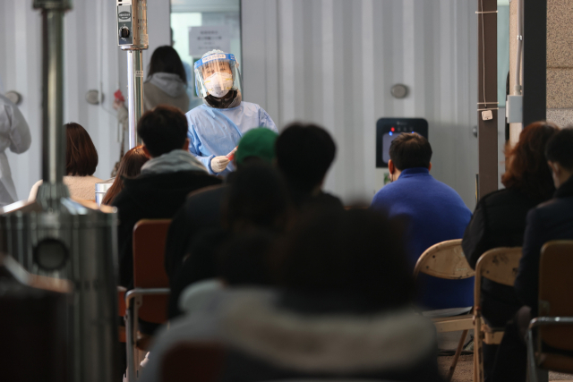 22일 오후 서울 동작구보건소에 마련된 선별진료소에서 의료진이 다음 검사자를 호명하고 있다. 연합뉴스