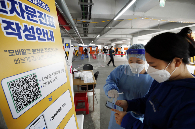22일 오전 광주 북구선별진료소에서 보건소 의료진들이 코로나19 모바일 스마트접수 시스템을 시연하고 있다. 북구 선별진료소는 오는 3월부터 모바일 접수 시스템을 운영, 문진표 사전 모바일 작성자를 대상으로 원스톱 검사 서비스를 제공한다. 연합뉴스