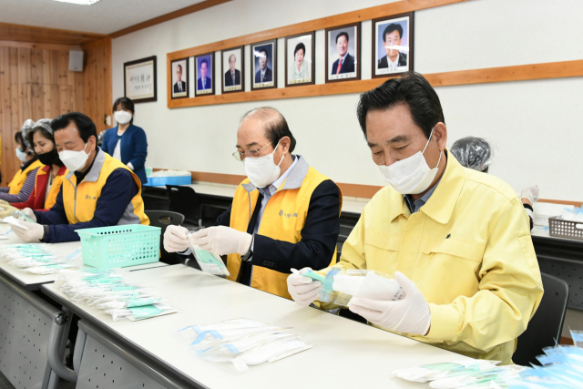 김문오 달성군수가 자원봉사자들과 함께 저소득층 가구에 지원할 수제 마스크 제작 작업을 돕고 있다. 달성군 제공