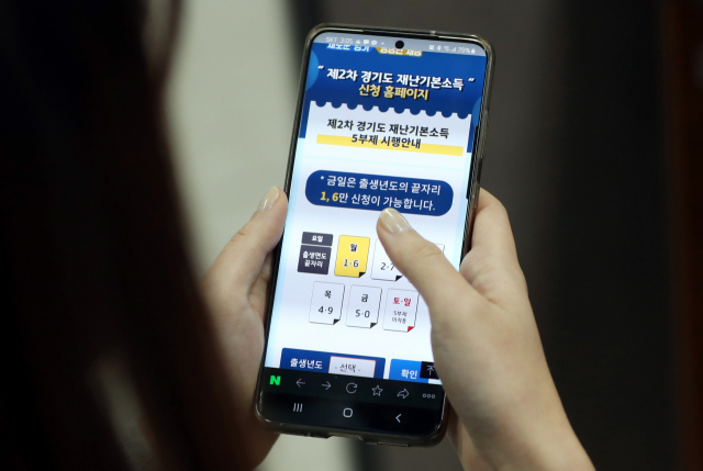 경기도 제2차 재난기본소득 신청 첫날인 1일 경기 수원시의 한 사무실에서 직장인들이 모바일 홈페이지를 통해 재난소득을 신청하고 있다. 연합뉴스