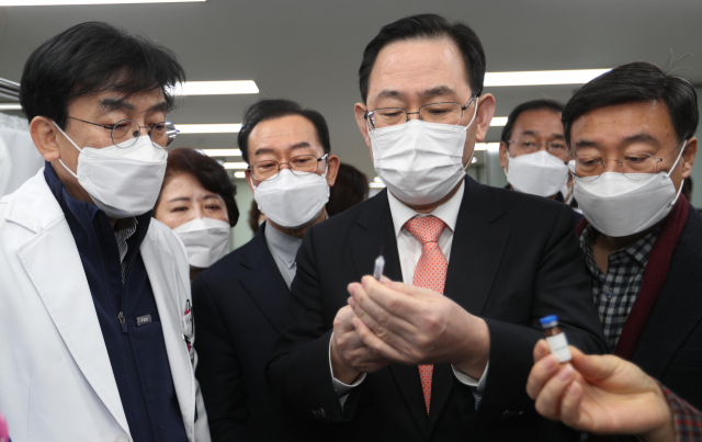 24일 오전 서울 중구 국립중앙의료원에 있는 코로나19 백신 중앙예방접종센터를 방문한 국민의힘 주호영 원내대표와 의원들이 정기현 국립중앙의료원장의 안내를 받으며 백신접종에 사용될 주사기를 살펴보고 있다. 연합뉴스