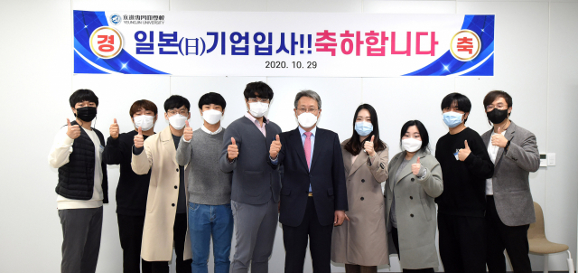 지난해 영진전문대를 졸업하고 일본 소프트뱅크 등에 입사하는 졸업생들이 출국에 앞서 대학 해외취업박람회장에서 최재영 총장(왼쪽서 여섯째)과 기념촬영을 하고 있다. 영진전문대 제공
