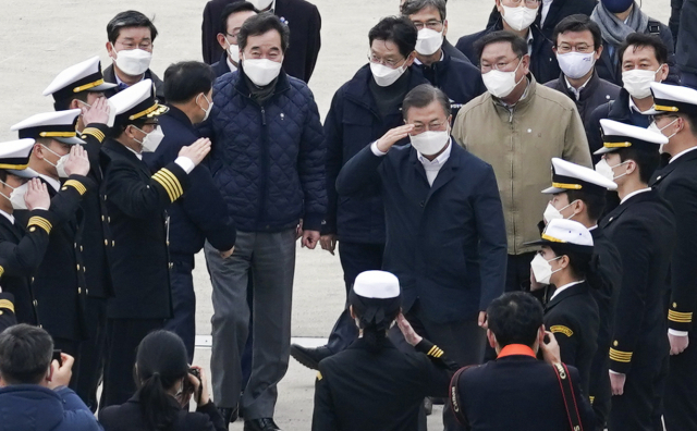 문재인 대통령이 25일 가덕도 공항 예정지 선상 시찰을 마치고 부산신항 다목적 부두에 위치한 해양대학교 실습선으로 이동하며 해양대 학생들의 경례를 받고 있다. 연합뉴스